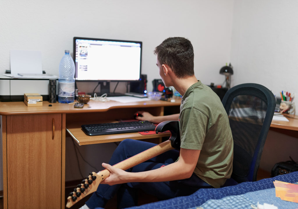 Jongen leert online gitaar spelen