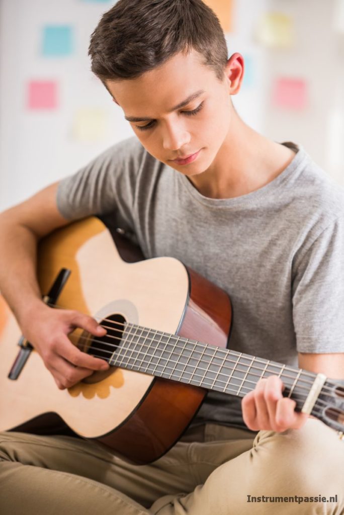 Jongen oefent op gitaar